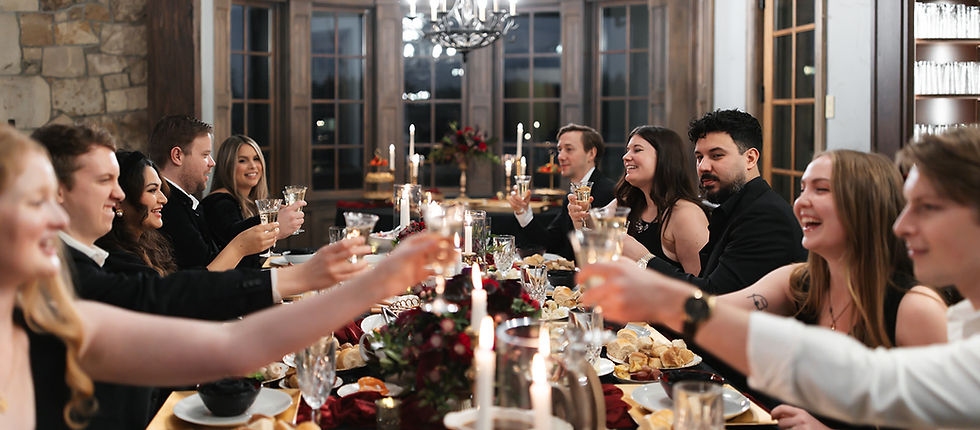 Guests raising a toast together at a long banquet table at Chateau de Lis