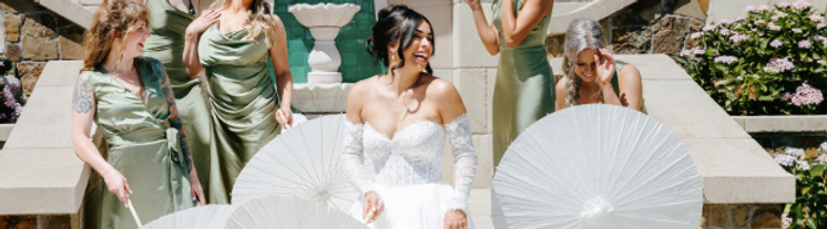 Bridesmaids with parasols in the stone courtyard at the Chateau de Lis