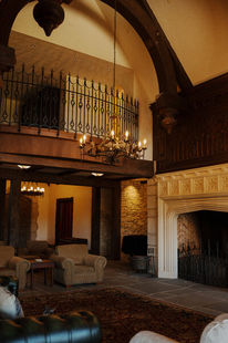Grand chateau living room with a vaulted wood-beamed ceiling and stone fireplace