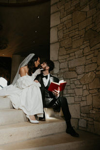 Bride and groom sharing a playful moment with a book on the chateau's stone stairs