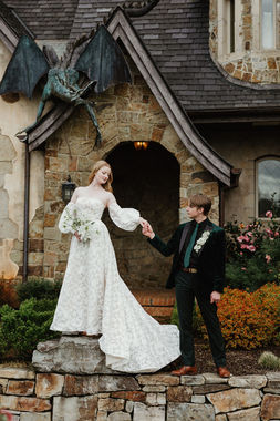 Bride and groom holding hands before the chateau's dragon-topped gable